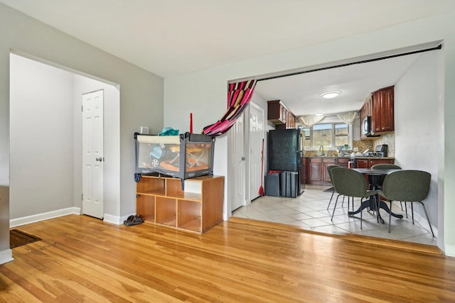 dining space with sink and light hardwood / wood-style floors