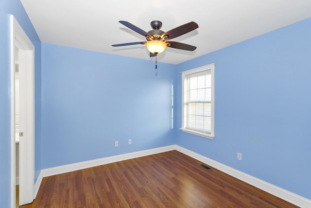 spare room featuring visible vents, ceiling fan, baseboards, and wood finished floors