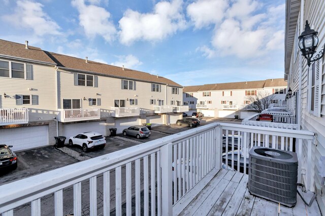 deck with a garage, a residential view, and cooling unit