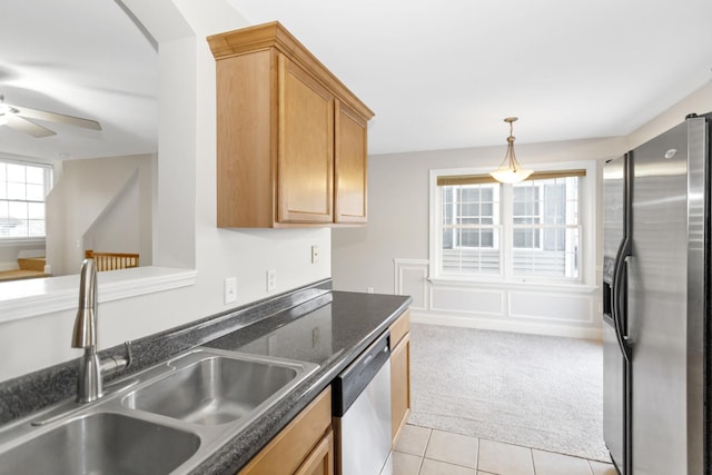 kitchen with light tile patterned floors, ceiling fan, light carpet, stainless steel appliances, and a sink