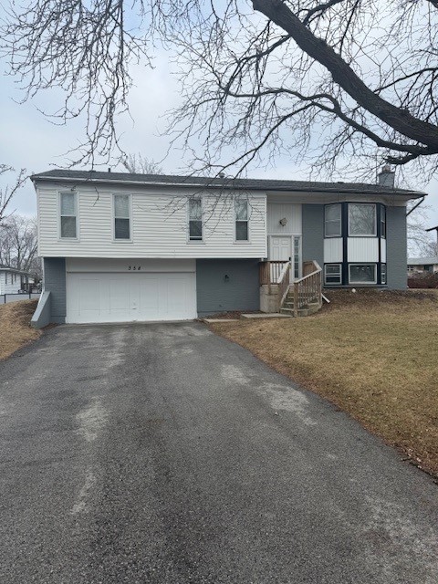 split foyer home featuring a garage and a front yard