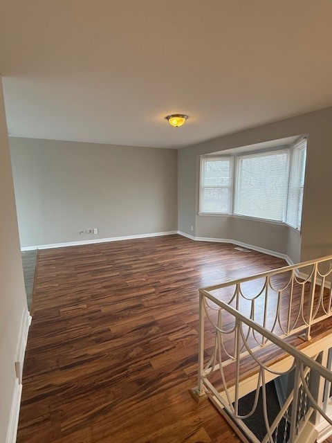 unfurnished room with dark hardwood / wood-style floors