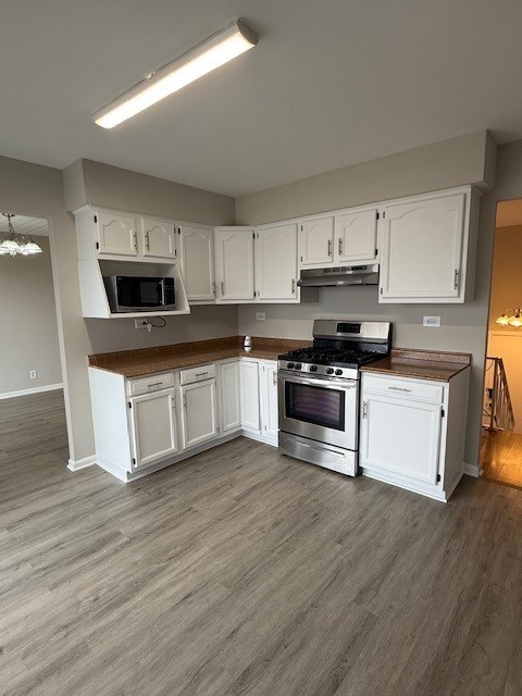 kitchen with white cabinetry, light hardwood / wood-style floors, and appliances with stainless steel finishes