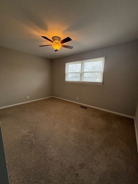 carpeted empty room featuring ceiling fan