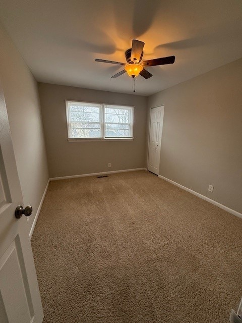 carpeted empty room featuring ceiling fan