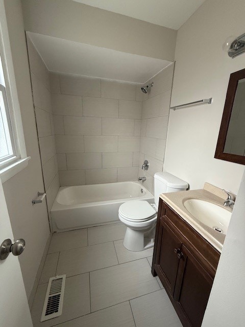 full bathroom featuring tiled shower / bath, vanity, toilet, and tile patterned floors