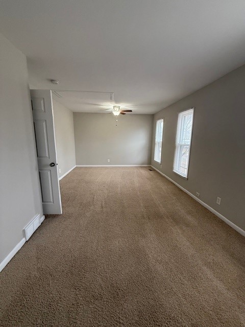 carpeted empty room featuring ceiling fan