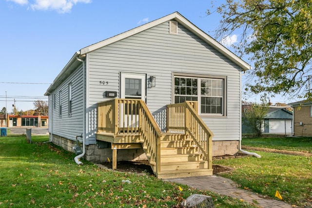 rear view of property featuring a lawn