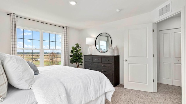 bedroom featuring multiple windows, visible vents, and light colored carpet