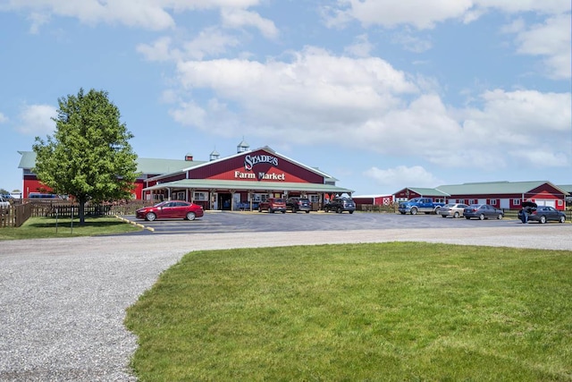 view of home's community with uncovered parking and a lawn