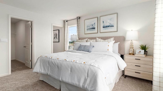 bedroom with light carpet, a spacious closet, and baseboards