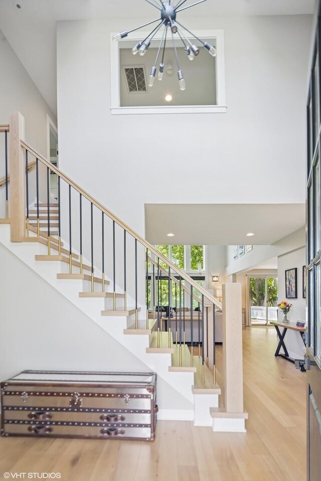37580 N Fairfield Rd, Lake Villa, IL 60046 - staircase with wood finished floors, a towering ceiling, and a chandelier