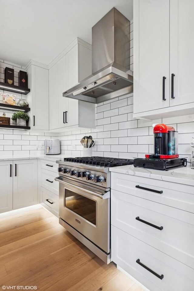 37580 N Fairfield Rd, Lake Villa, IL 60046 - kitchen featuring wall chimney exhaust hood, stainless steel range, white cabinetry, and tasteful backsplash