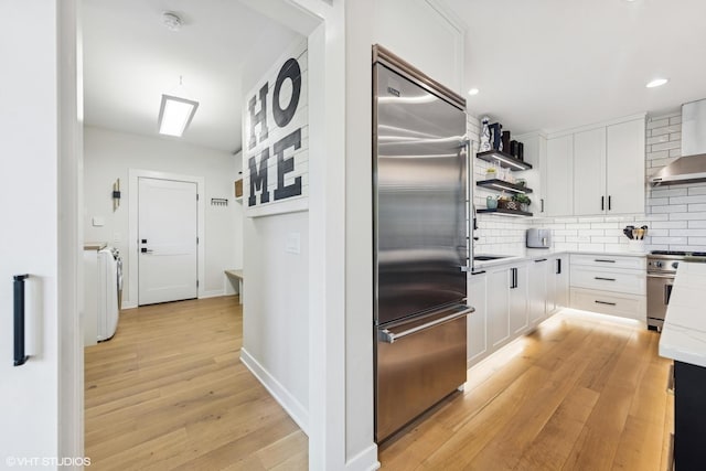 37580 N Fairfield Rd, Lake Villa, IL 60046 - kitchen featuring premium appliances, open shelves, wall chimney exhaust hood, decorative backsplash, and light wood finished floors