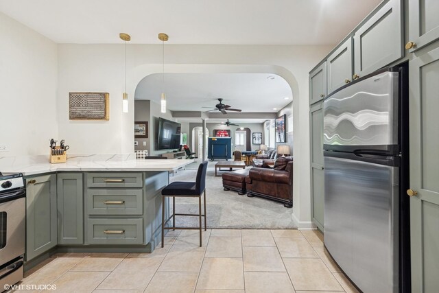 37580 N Fairfield Rd, Lake Villa, IL 60046 - kitchen featuring arched walkways, stainless steel appliances, ceiling fan, light colored carpet, and light stone counters