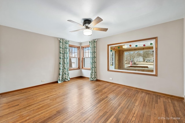 unfurnished room with baseboards, ceiling fan, and light wood-style floors