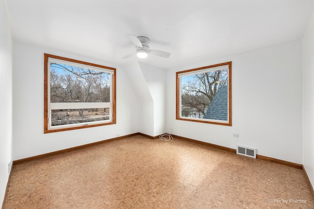 spare room featuring a ceiling fan, visible vents, and baseboards