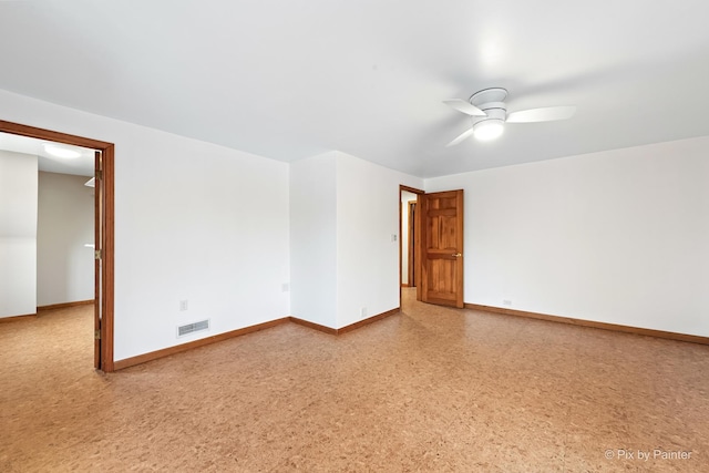 unfurnished room featuring a ceiling fan, visible vents, and baseboards