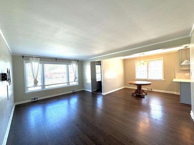 unfurnished living room with crown molding and dark hardwood / wood-style floors