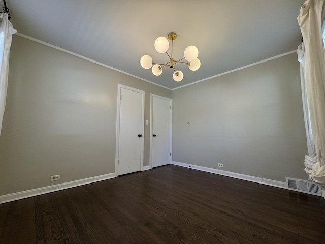 spare room featuring ornamental molding, dark hardwood / wood-style flooring, and an inviting chandelier