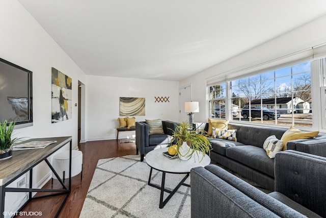 living room featuring baseboards and dark wood-type flooring