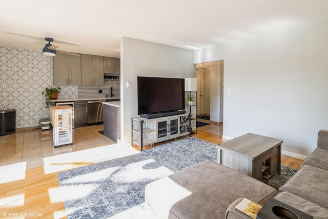 living room with wine cooler, sink, and light hardwood / wood-style flooring