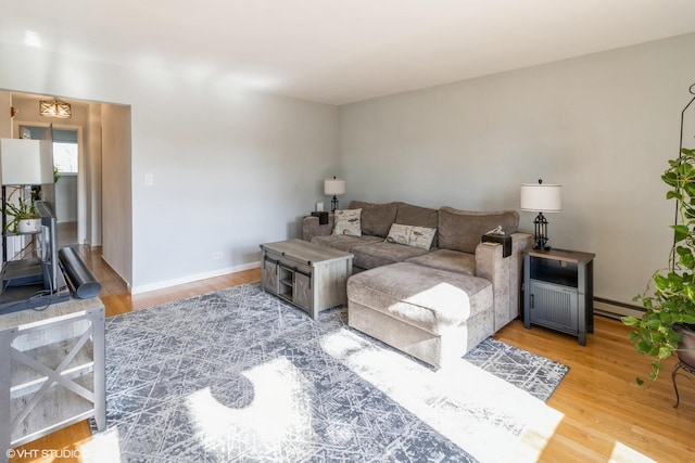 living room with a baseboard heating unit and light hardwood / wood-style floors