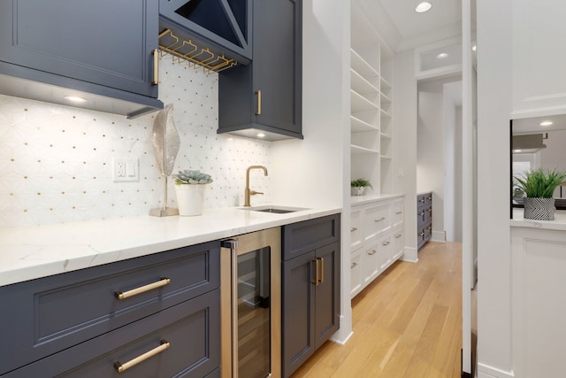 kitchen featuring sink, white cabinets, wine cooler, light stone countertops, and light hardwood / wood-style flooring