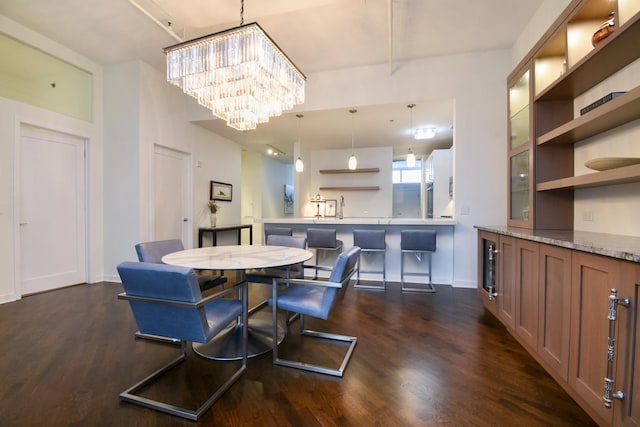 dining area with dark hardwood / wood-style flooring and an inviting chandelier