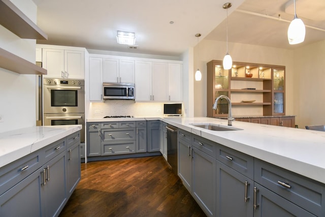 kitchen with sink, decorative light fixtures, stainless steel appliances, and white cabinets