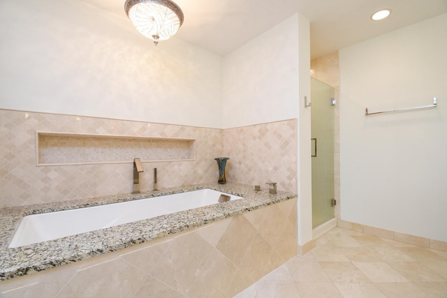 bathroom with tile patterned floors, independent shower and bath, and sink