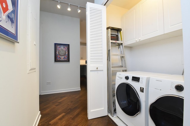 laundry area featuring cabinets, rail lighting, dark hardwood / wood-style floors, and independent washer and dryer