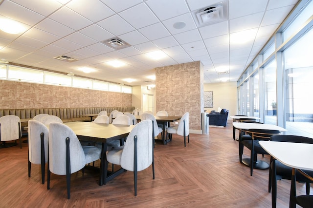 dining space with parquet flooring and a paneled ceiling