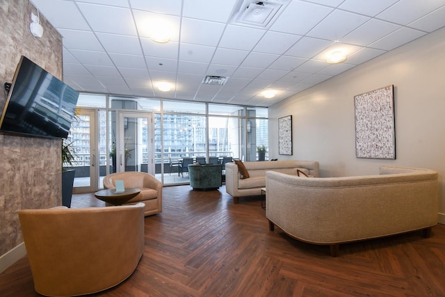 living room with floor to ceiling windows, a drop ceiling, and dark parquet floors