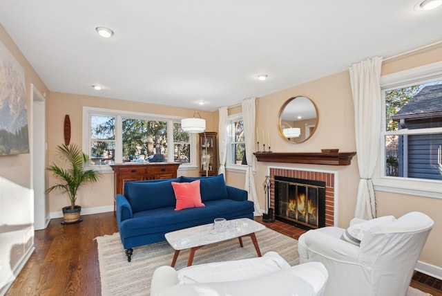 living area with baseboards, a fireplace, wood finished floors, and a healthy amount of sunlight