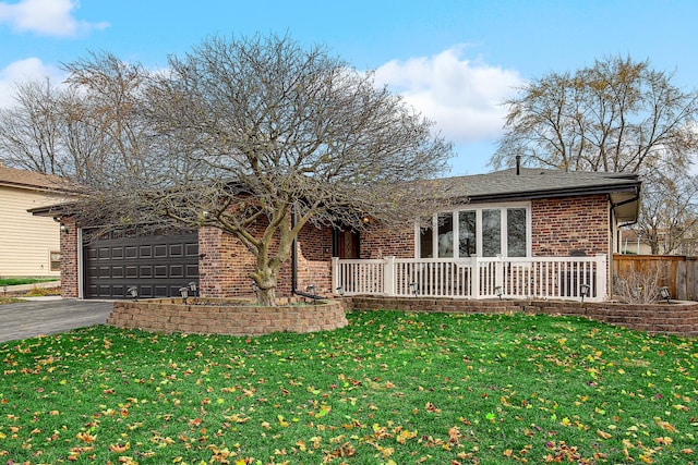 rear view of house featuring a garage and a lawn