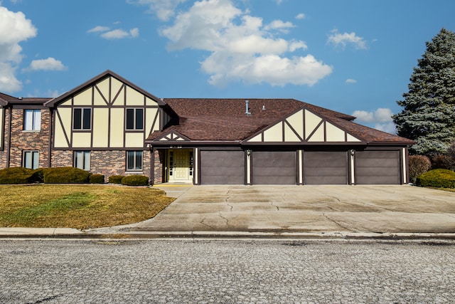 tudor home featuring a garage and a front yard