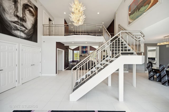 stairway with an inviting chandelier, tile patterned floors, and a high ceiling