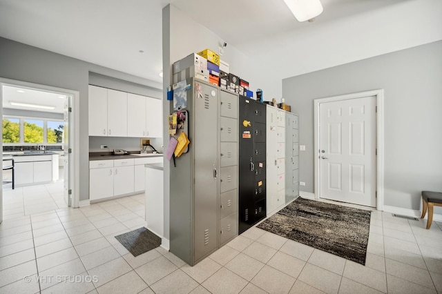 kitchen featuring white cabinetry, sink, and light tile patterned floors