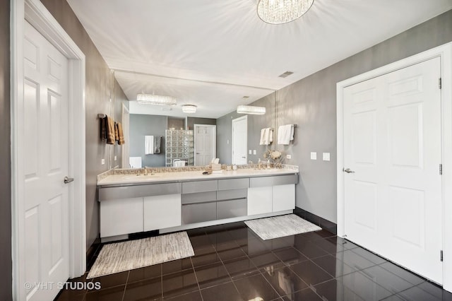 bathroom with tile patterned flooring, vanity, and a chandelier