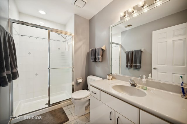 bathroom featuring an enclosed shower, vanity, tile patterned floors, and toilet