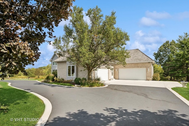 view of property hidden behind natural elements featuring a garage