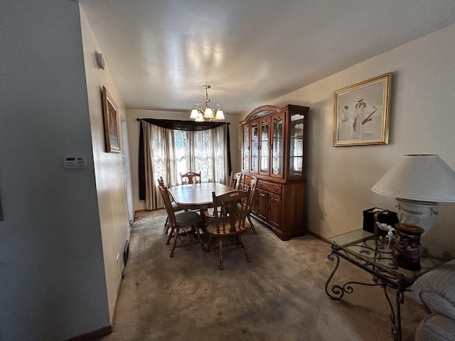 dining room featuring baseboards, a chandelier, and carpet flooring