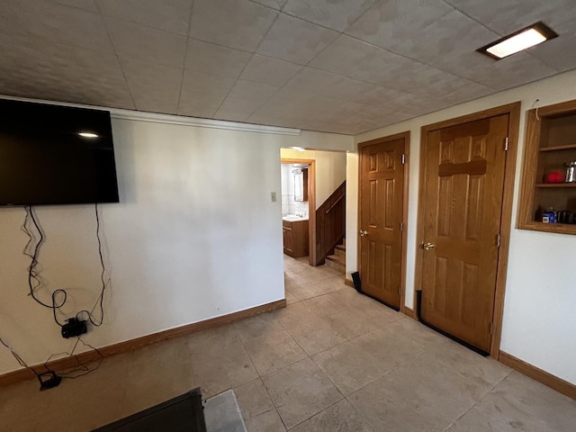 basement with stairs and baseboards