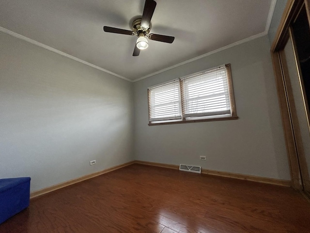 unfurnished bedroom with dark wood finished floors, visible vents, crown molding, and baseboards