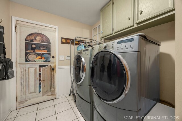 laundry room with wainscoting, washing machine and dryer, cabinet space, and light tile patterned floors