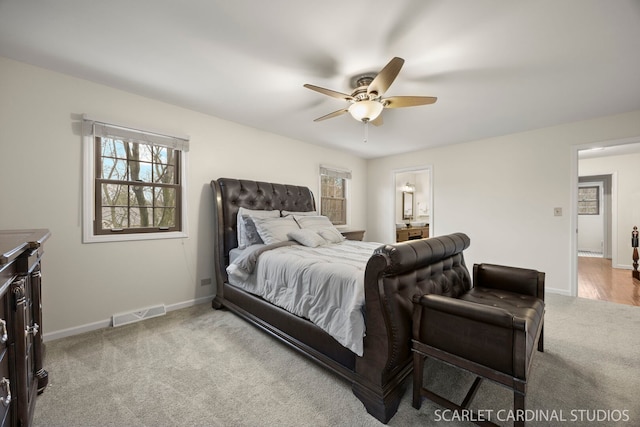 carpeted bedroom featuring visible vents, ceiling fan, connected bathroom, and baseboards