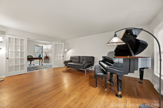 living area featuring french doors, light wood-type flooring, and baseboards