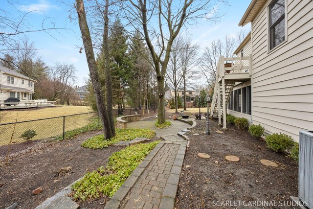 view of yard featuring stairway, central AC unit, and fence