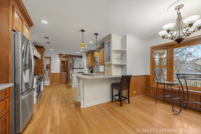 kitchen with wainscoting, appliances with stainless steel finishes, brown cabinets, and open shelves